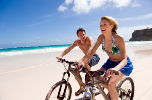 Young couple cycling on a beach